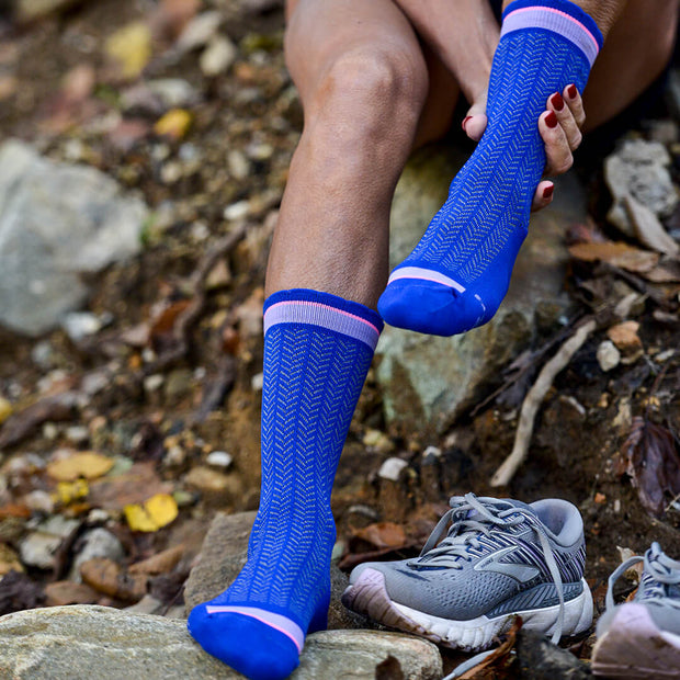 Runner resting in compression crew socks in blue herringbone